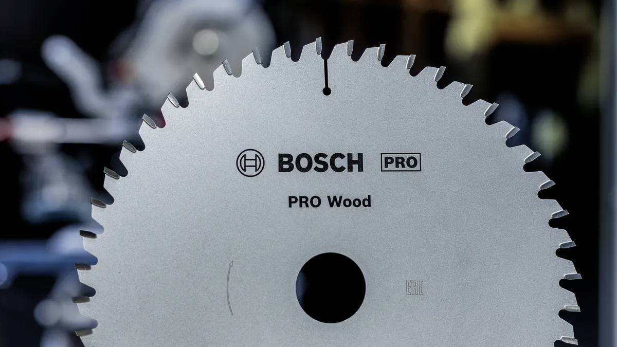 Fűrészlap körkép, amelyen a 'Bosch PRO Wood' felirat szerepel, fa megmunkálásához tervezve, éles, egyenletesen elhelyezkedő fogakkal, elmosódott háttér előtt.