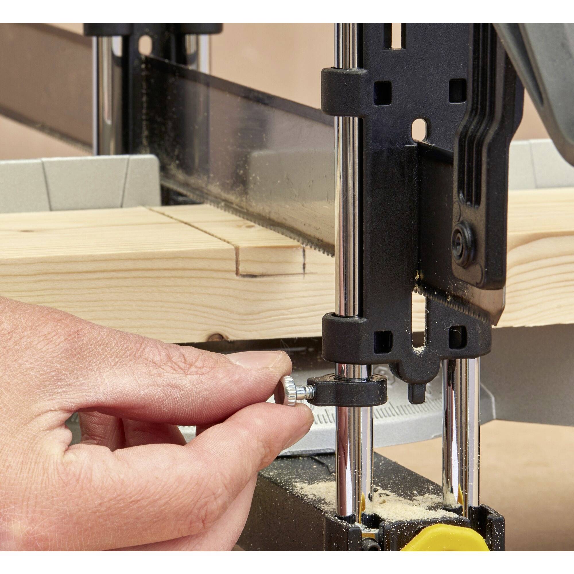 Egy személy beállítja a dekopírfűrészt, egy fadeszkát szorít és ellenőrzi a fűrészfogakat.