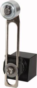 Egy kis fekete blokkra fém rögzítőkapocs van csavarral és csavarfejjel rögzítve, valószínűleg egy gépalkatrész vagy rögzítőelem.