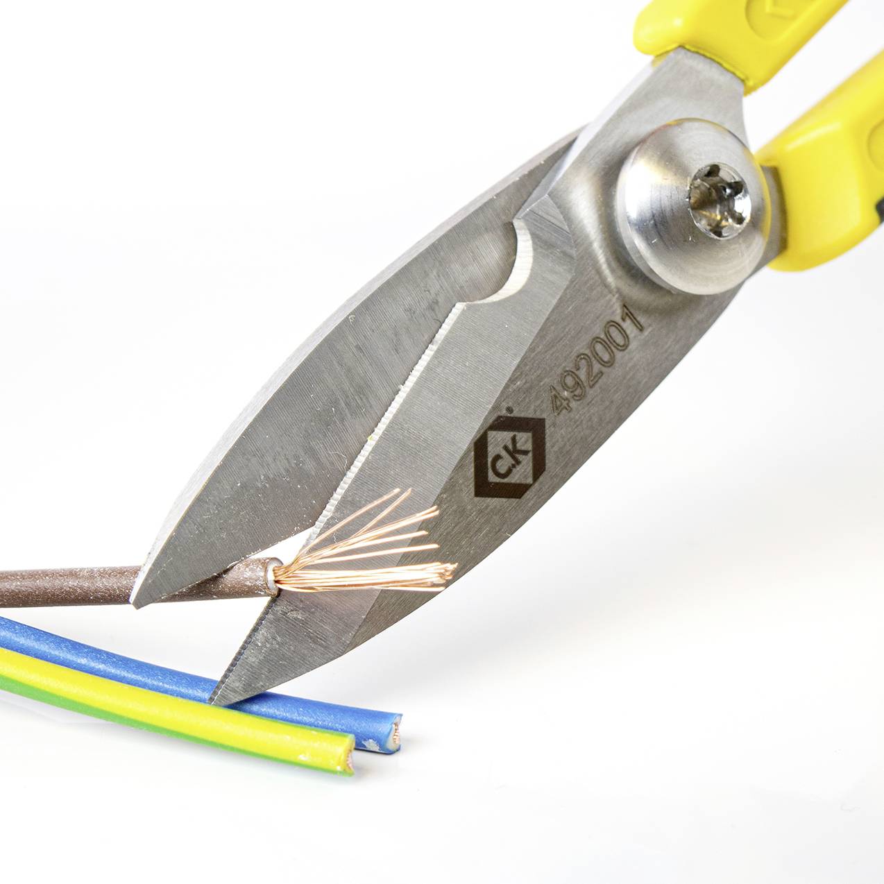 Egy fogó elvág egy több színes vezetékből álló elektromos kábelt.