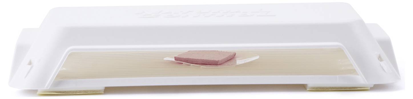 Egy egérfogó, amelynek az elsütőfelületére egy darab csali van helyezve, és készen áll egy egér elfogására.