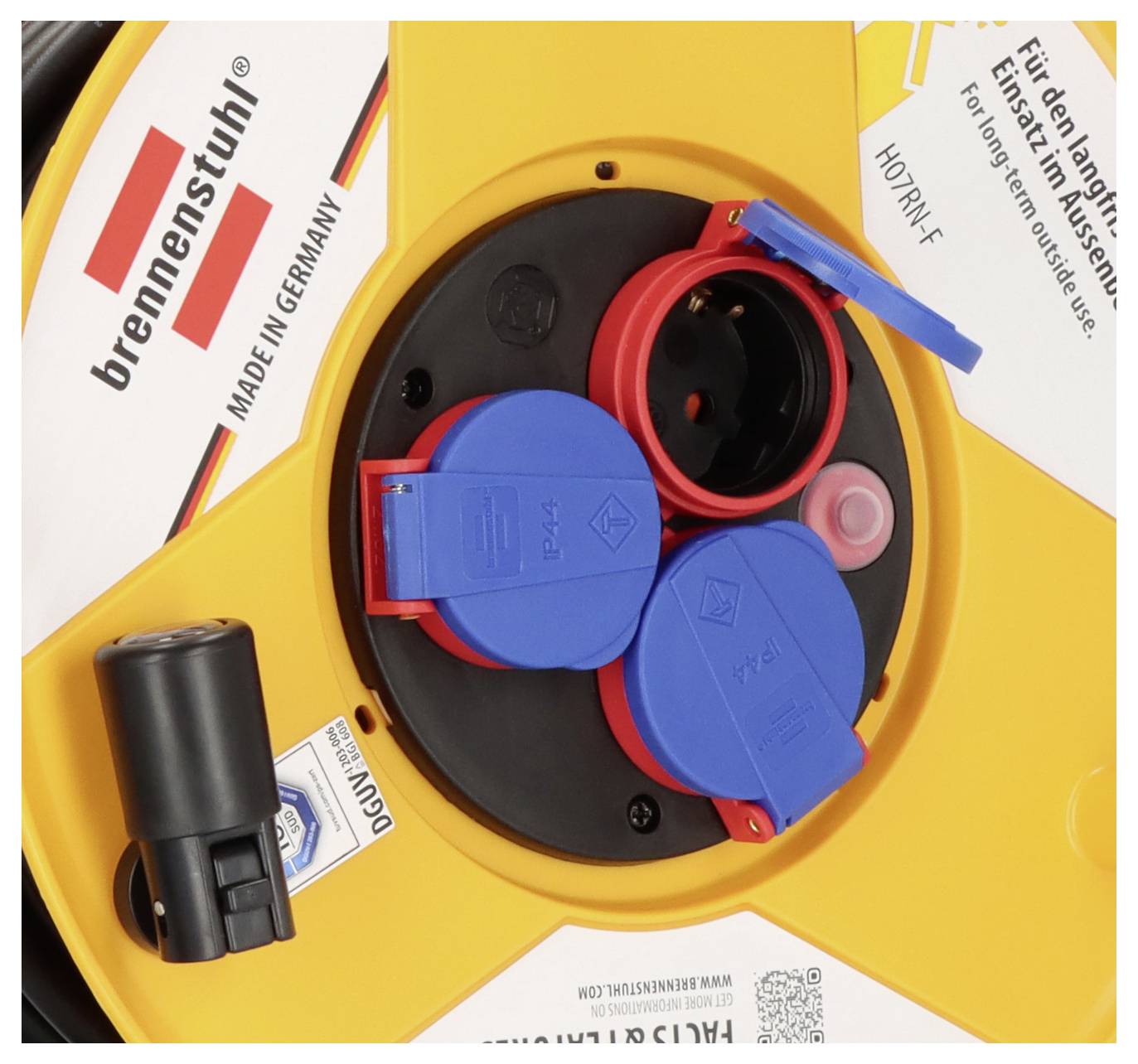 Egy Brennenstuhl energiaegység közeli képe, több piros és kék aljzattal és egy fekete dugóbetéttel, amelyen a „MADE IN GERMANY" felirat látható.