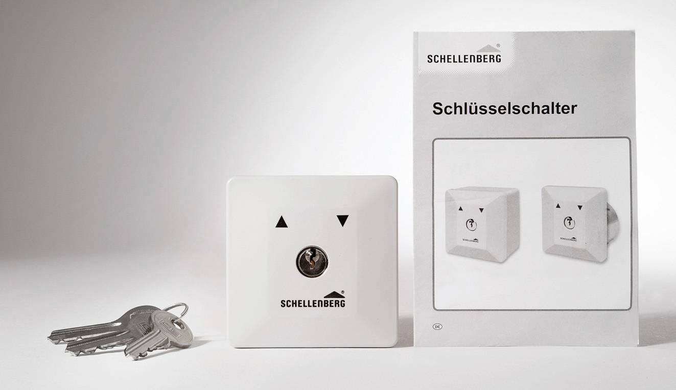 Schellenberg kulcskapcsoló egy termékcsomagolás mellett, amely felfelé és lefelé irányuló mozgás szimbólumait tartalmazza. Négy kulcs fekszik mellette.