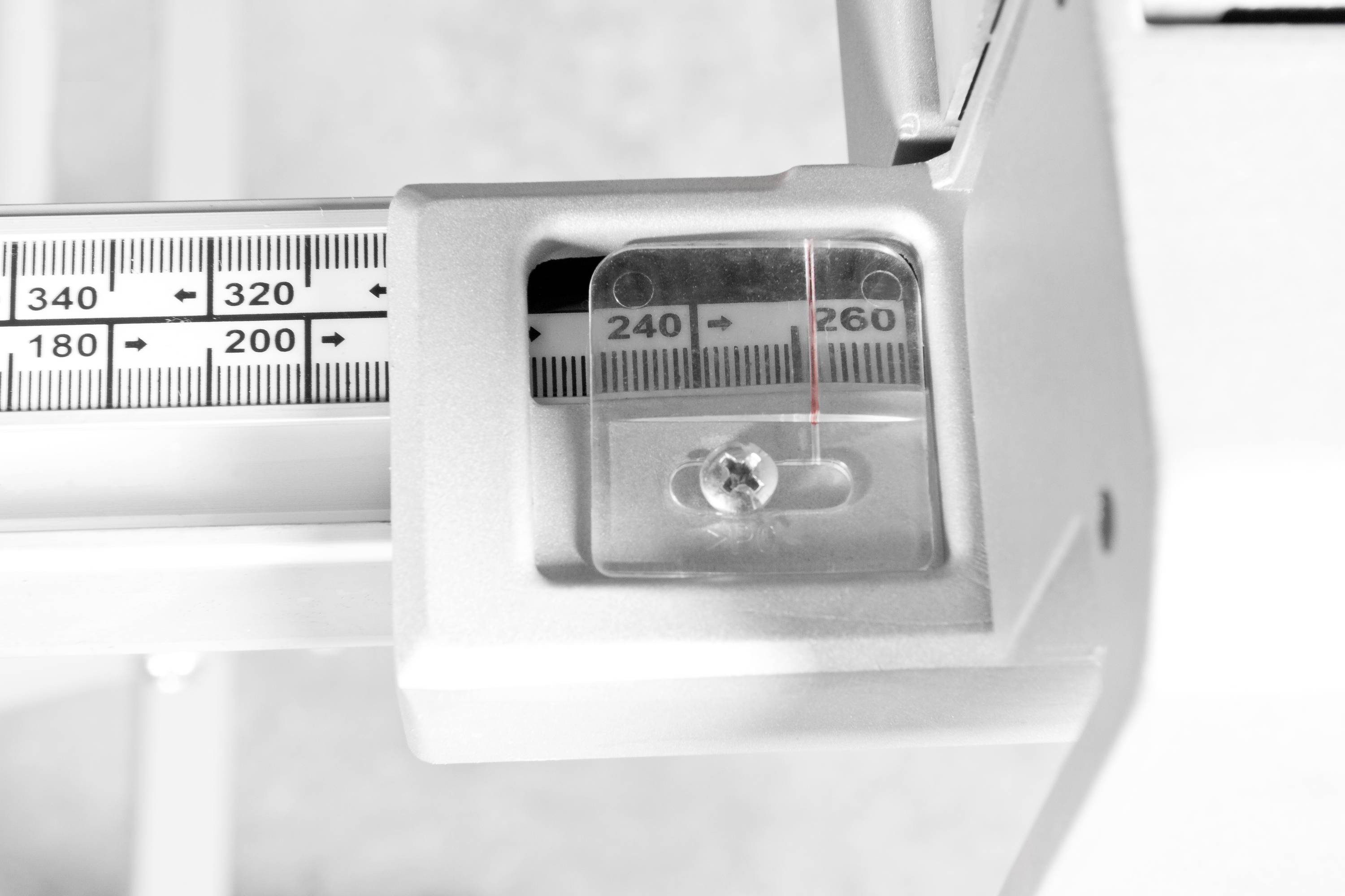 Egy mechanikus mérleg kb. 244 kg súlyt mutat. A mérőskála jól látható.
