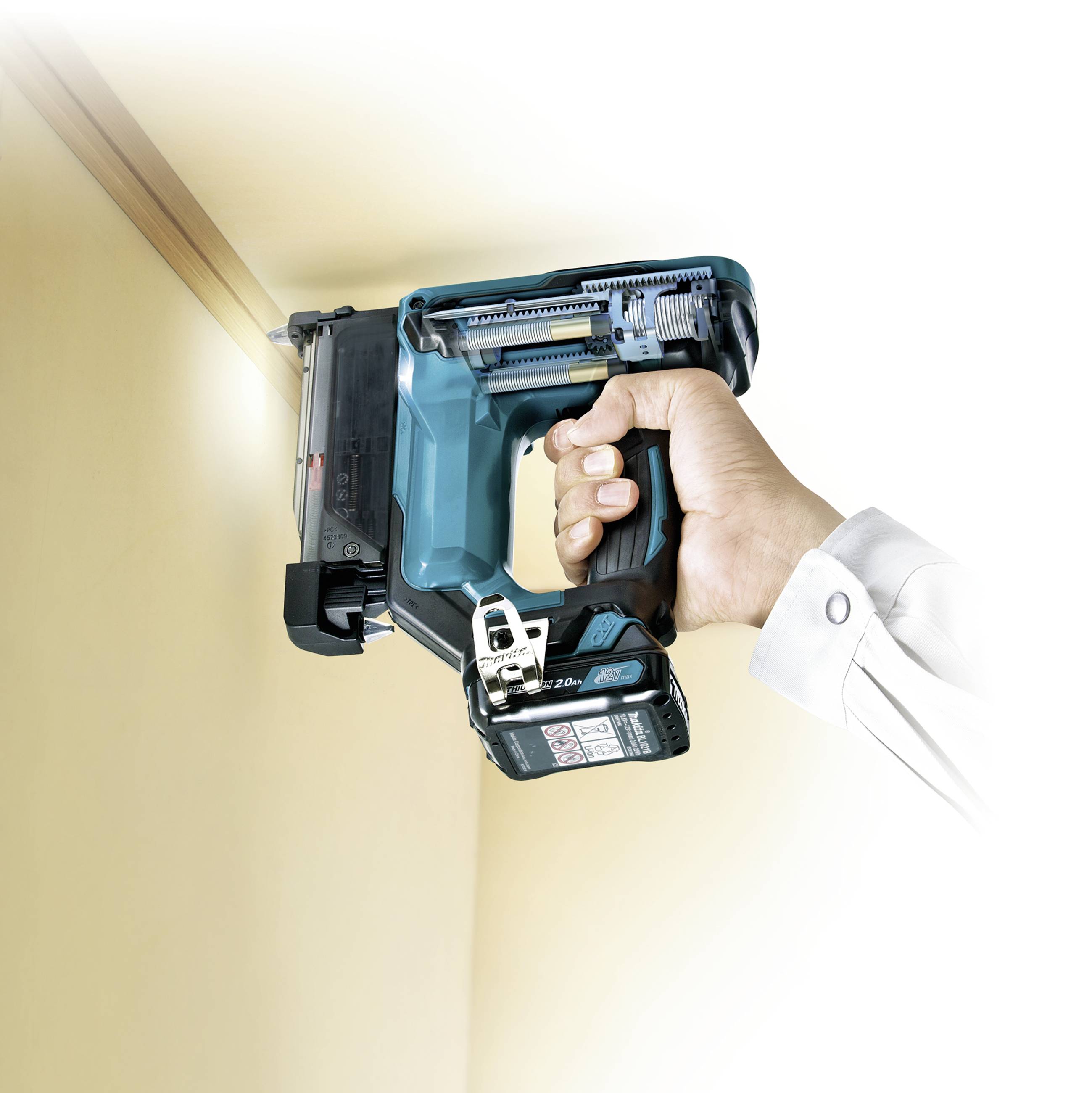 Egy ember egy elektromos szögbelövőt tart, és egy famennyezeti lécre irányítja, hogy rögzítse azt.