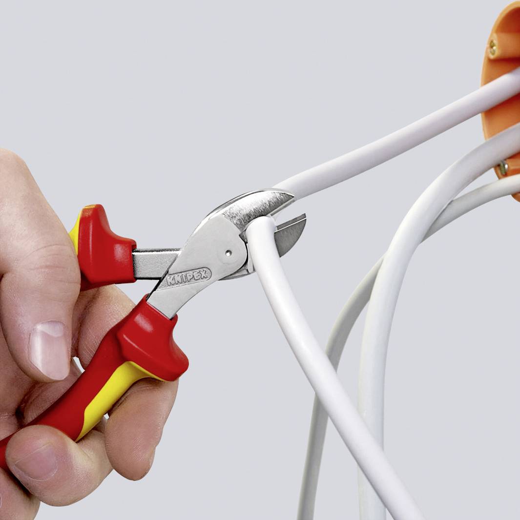 Egy személy egy piros és sárga kábelcsípővel egy vastag fehér kábelt vág át. A kábel több szálból áll.