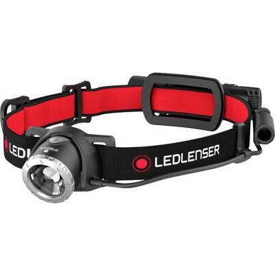 Egy fekete LED-fejlámpa piros belső szalaggal. A fejlámpa állítható pánttal és nagy lencsével rendelkezik elöl.