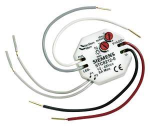 Egy elektronikai alkatrész több csatlakoztatott kábellel és két piros gombbal. Címke: 'Siemens S7C8212-0'.