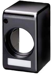 Egy fekete, téglalap alakú tok, amelynek középen kerek nyílása van. Úgy néz ki, mint egy elektronikai eszköz burkolata.