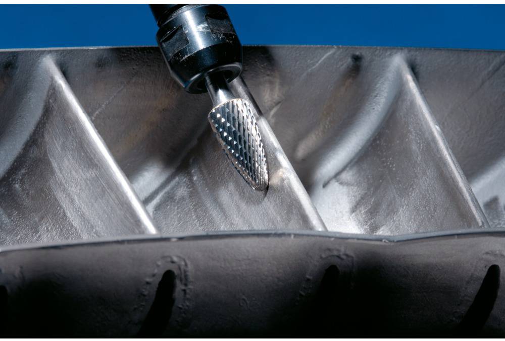 Egy csiszolószerszám precíziós hornyokat munkál meg egy fémfelületen. A fő hangsúly a anyagleválasztási folyamaton van.