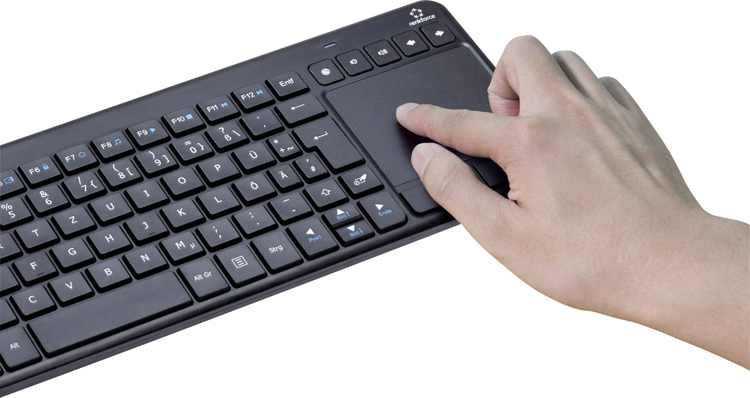Egy kéz érinti a touchpadot egy vezeték nélküli billentyűzeten, amely egy fehér felületen fekszik.