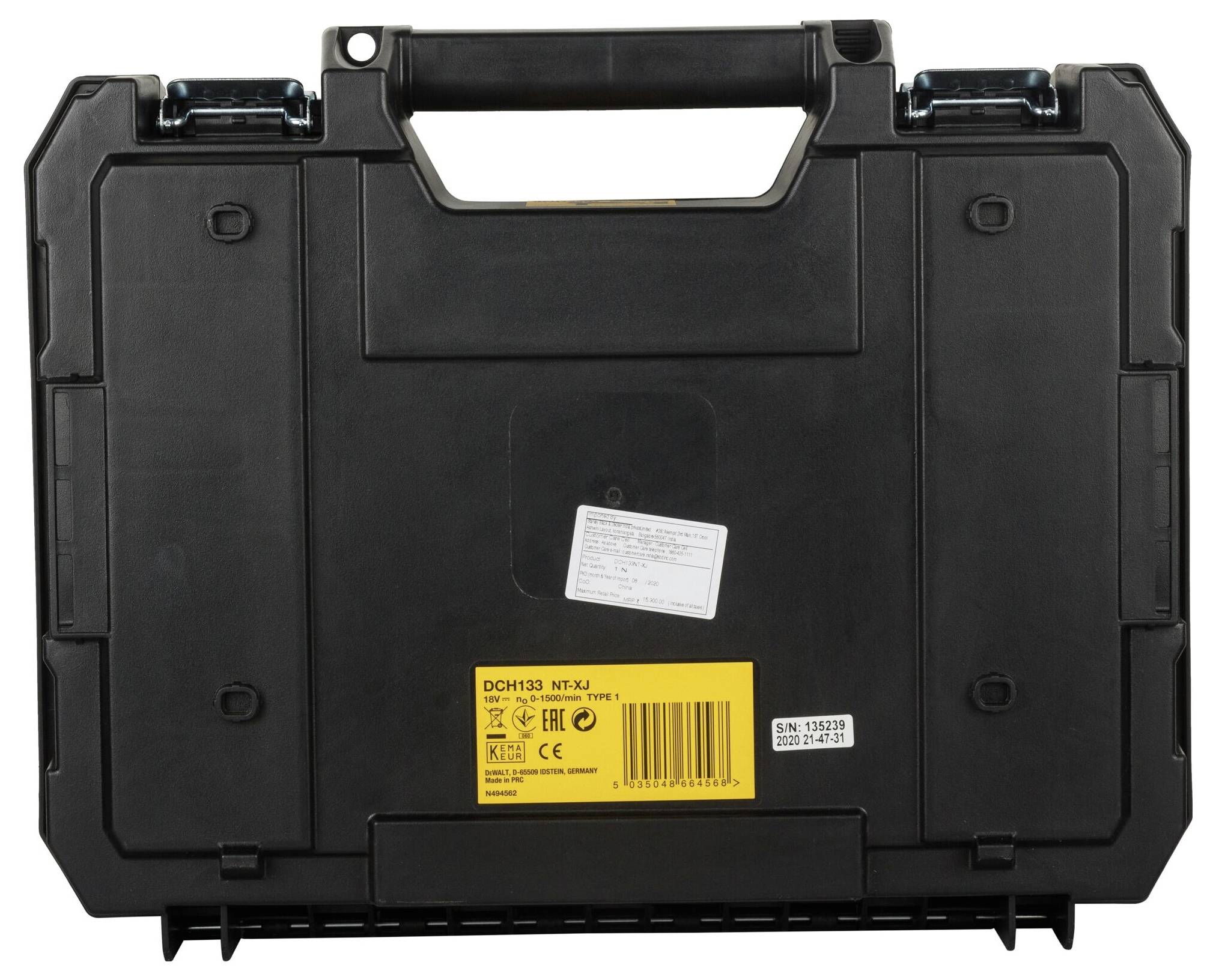 Fekete műanyag koffer, hátulról látható. Sárga címke műszaki adatokkal és sorozatszámmal.