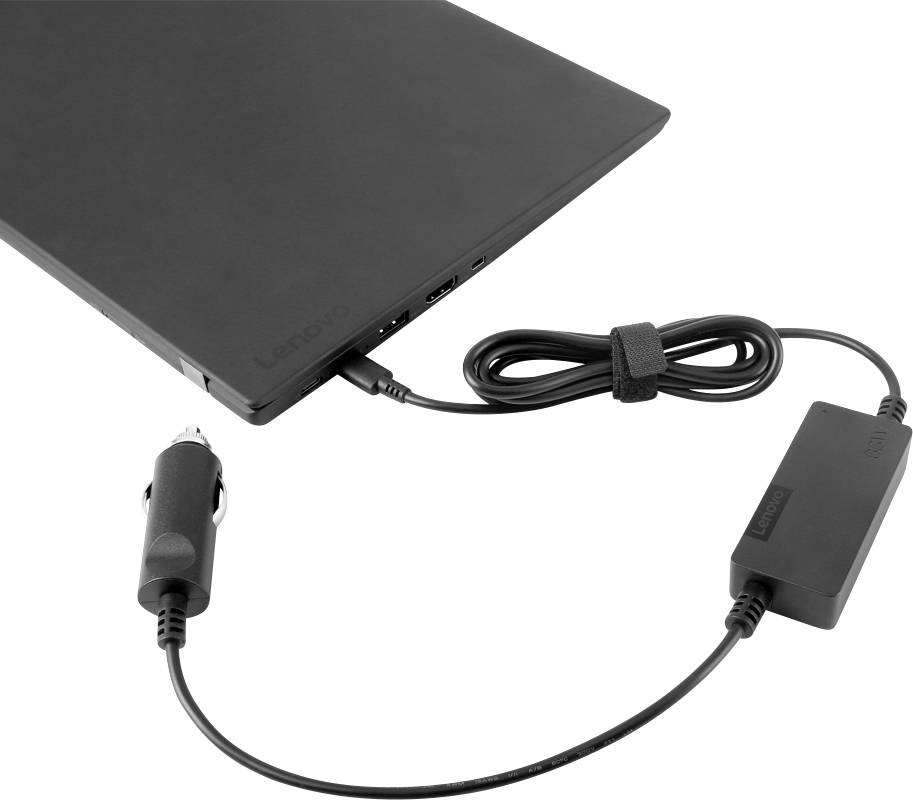 Egy fekete notebook egy speciális kábel és egy adapter segítségével csatlakozik egy áramforráshoz.