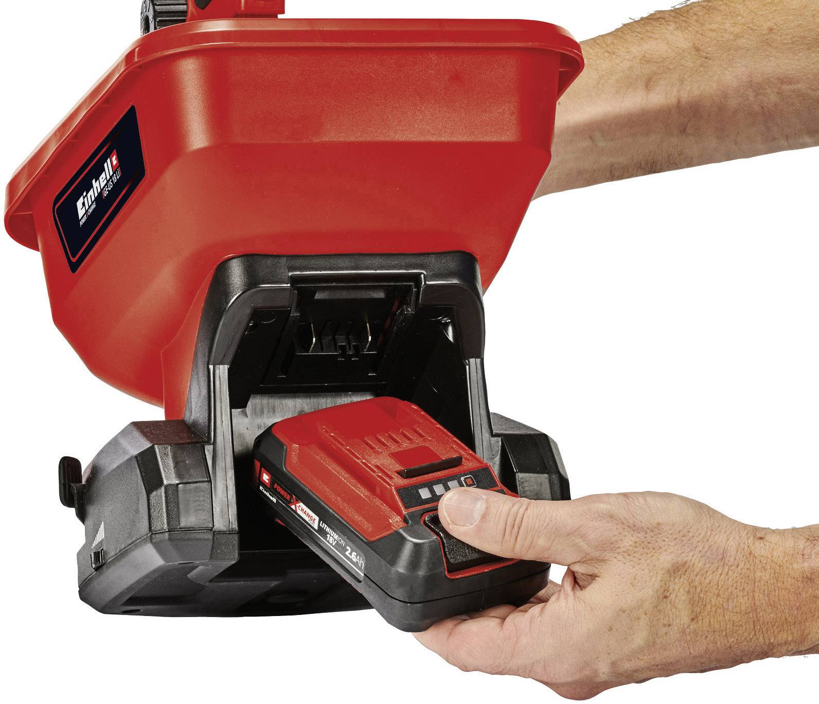 Egy személy egy akkumulátort helyez be egy piros-fekete készülékbe, amely egy szerszámra vagy kerti eszközre hasonlít.