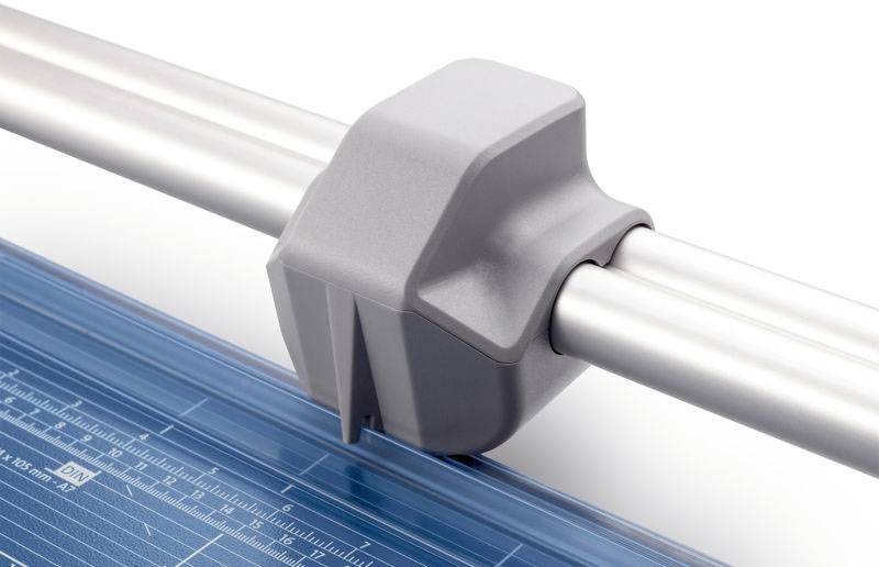 Papírvágógép szürke vágóegységgel fémvezető sínén és kék vonalzóval, rajta mérőjelzésekkel.