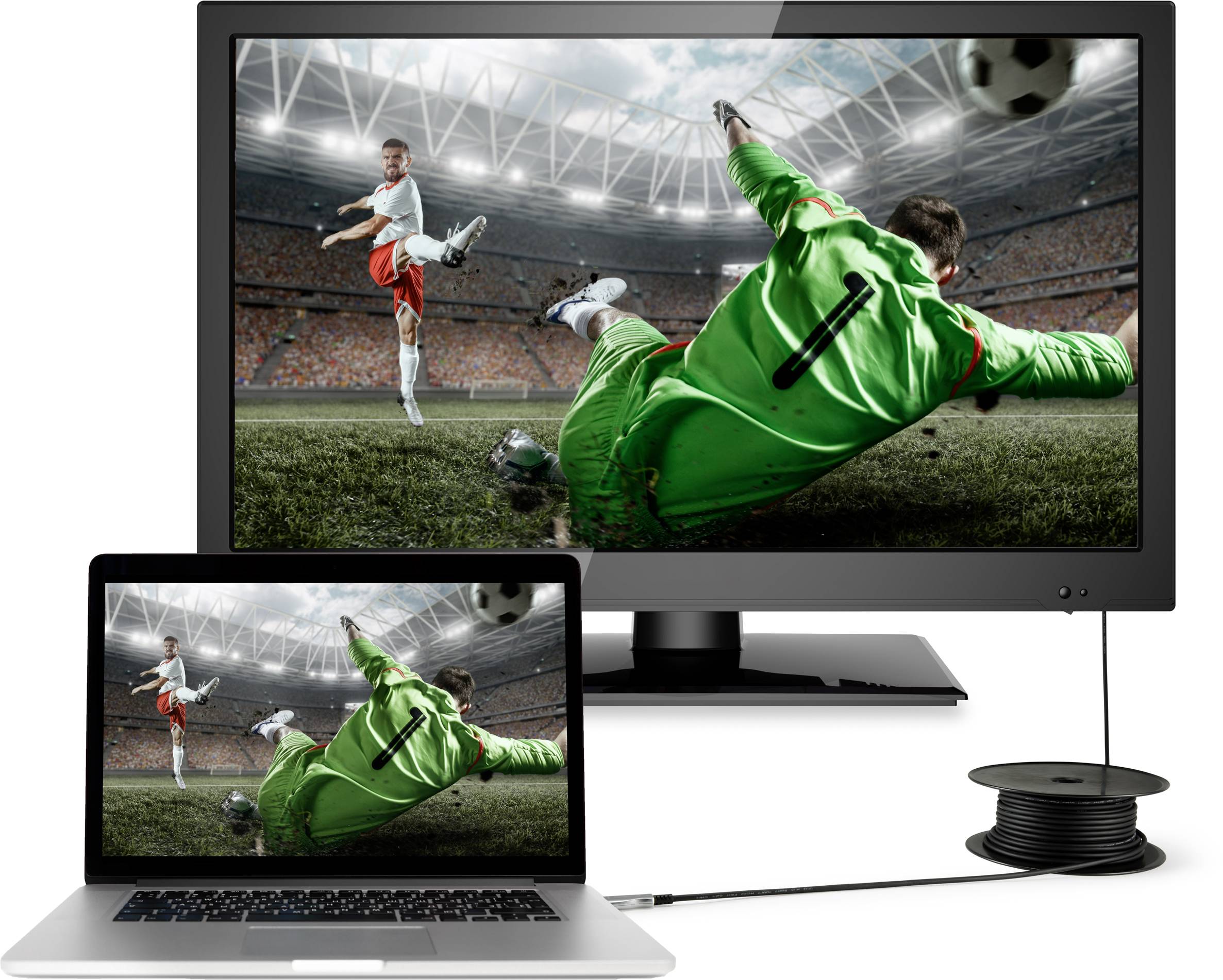 Egy zöld mezős kapus megpróbál egy futball labdát elkapni, miközben egy játékos rúgja, egy pályán egy stadionban. A kép egy monitoron és egy laptopen jelenik meg.