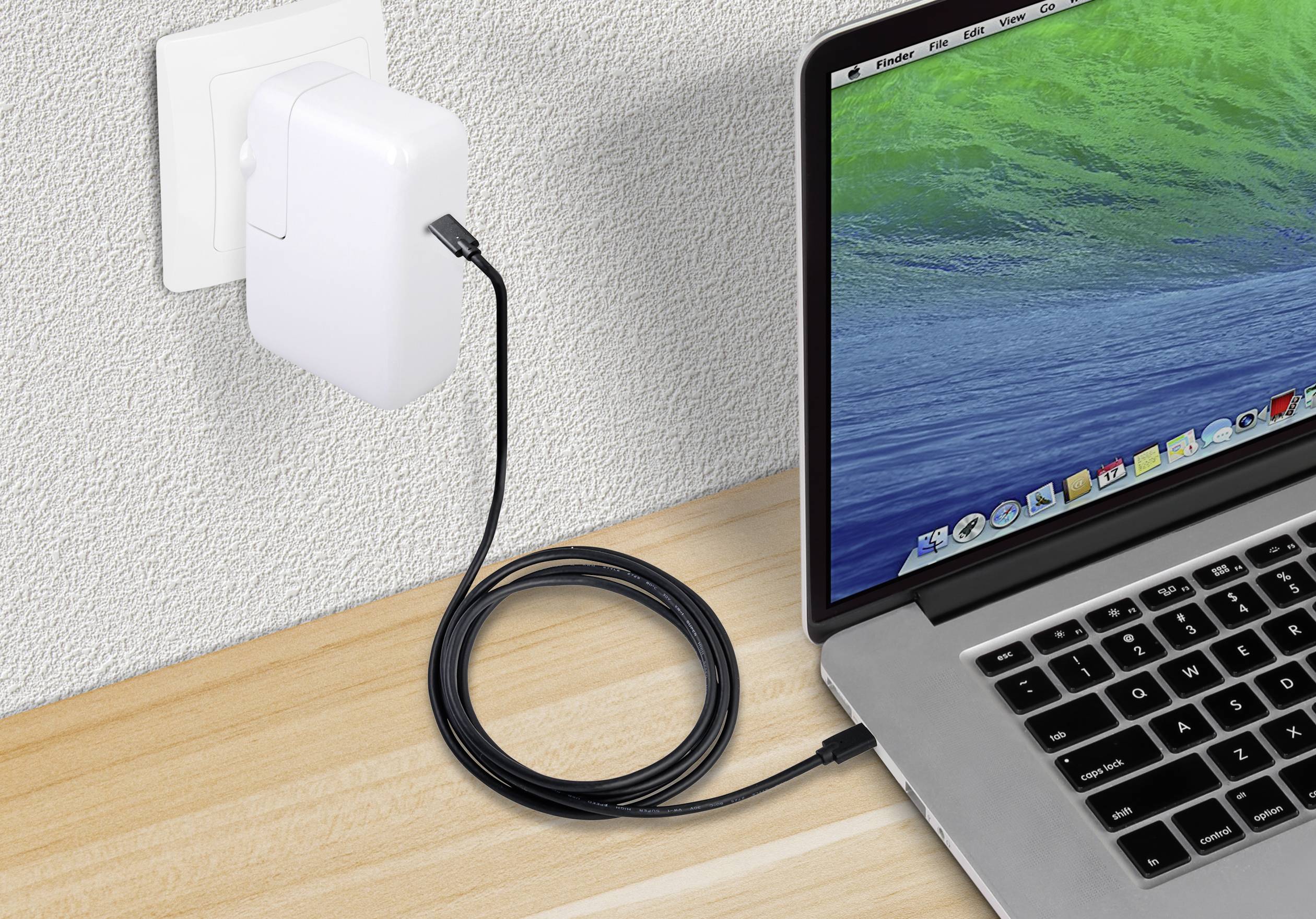 Egy laptop egy hosszú USB-kábellel van csatlakoztatva egy elektromos aljzathoz, hogy feltöltje az akkumulátorát.