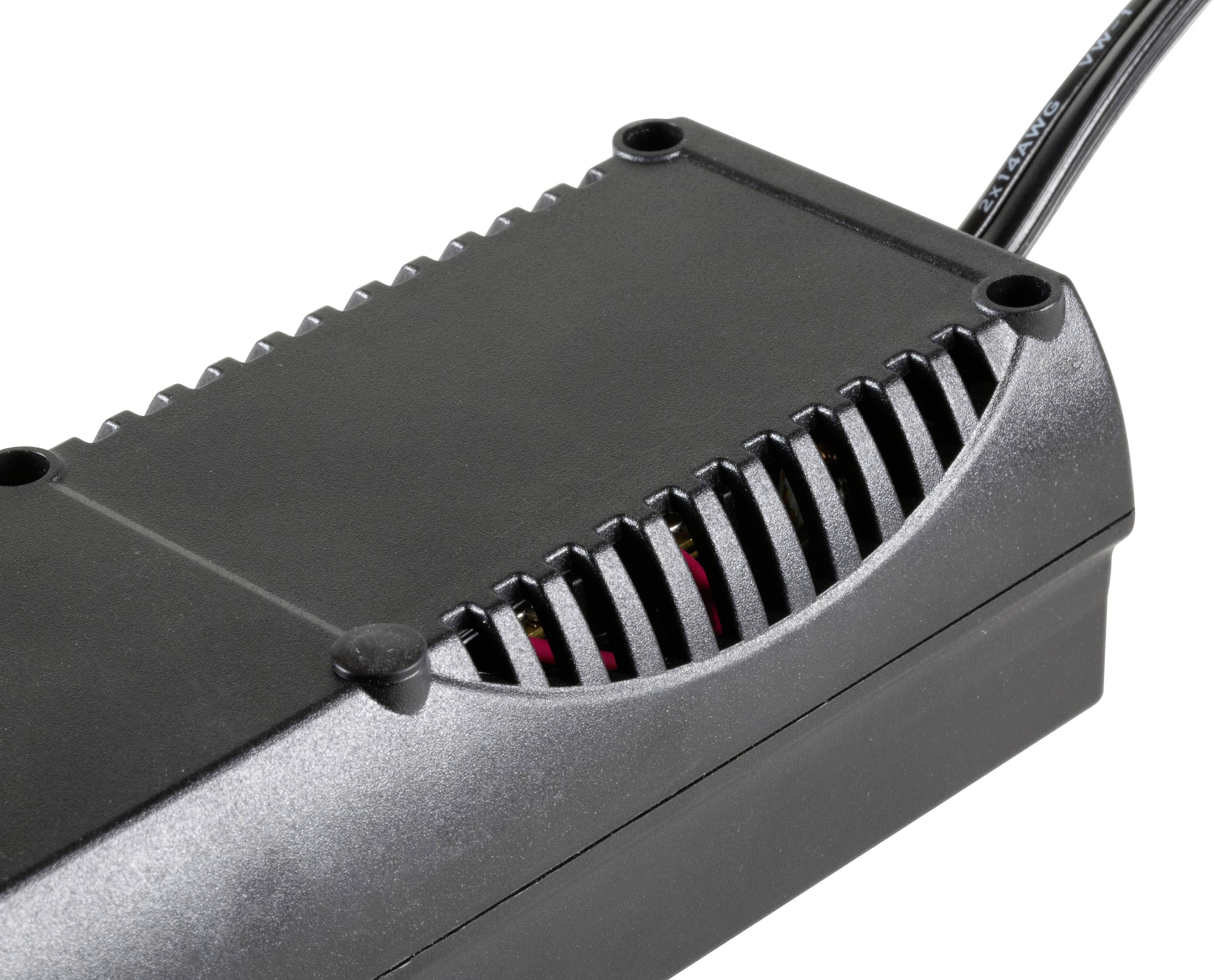 Egy fekete elektronikus adapter szellőzőnyílásokkal, félig oldalnézetből láthatóan. Egy fekete kábel csatlakoztatva van.