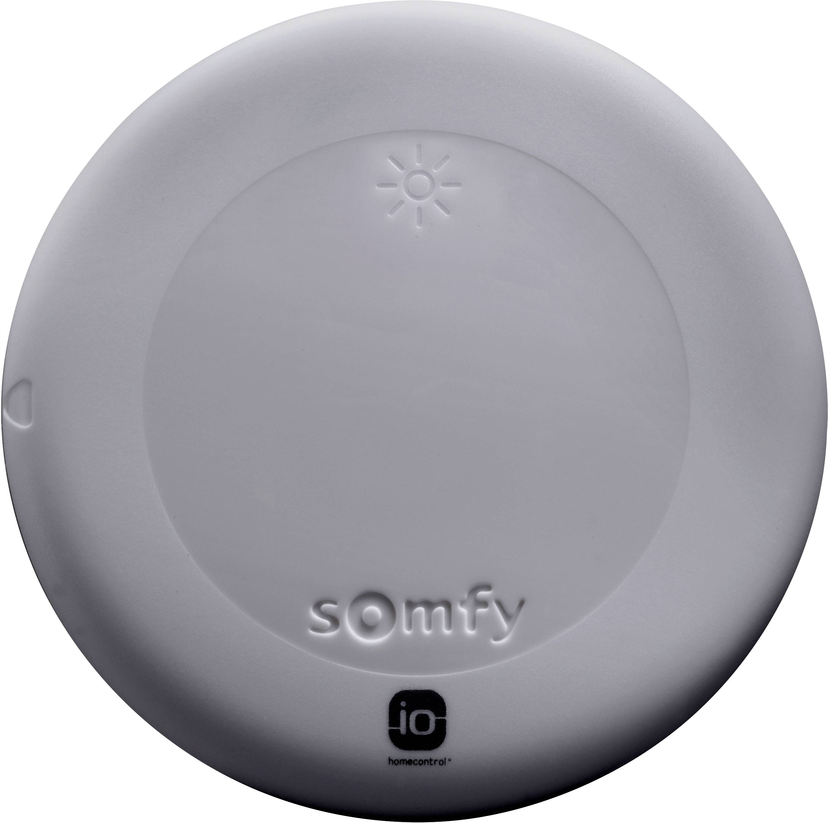 Kerek, fehér Somfy eszköz egy kis nap ikonnal felül és egy 'io homecontrol' logóval alul.