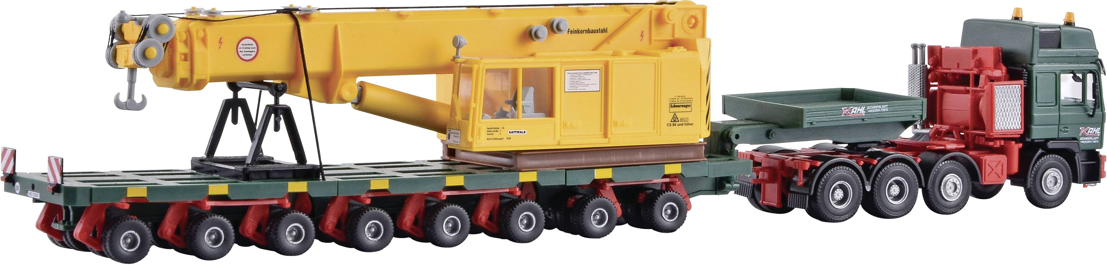 Egy sárga darukarral rendelkező modell-teherautó több tengelyes utánfutón. A daru ki van nyújtva és részletgazdagon megformázott.