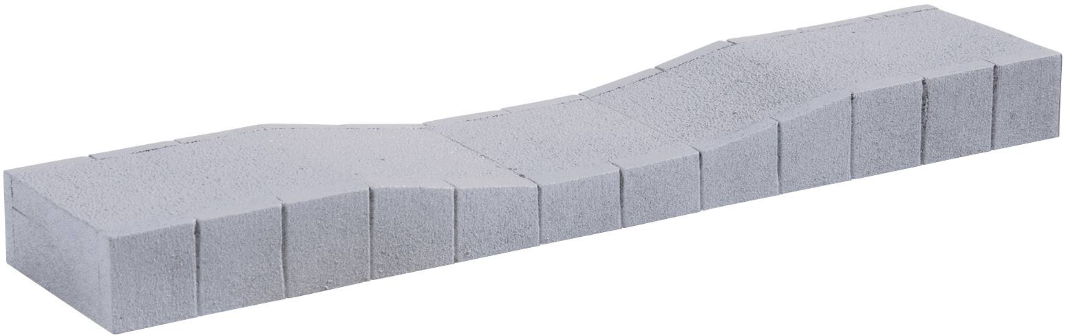 Lejtős felületű beton szegélykő, amely lágy ívet hoz létre járdákon vagy utakon.