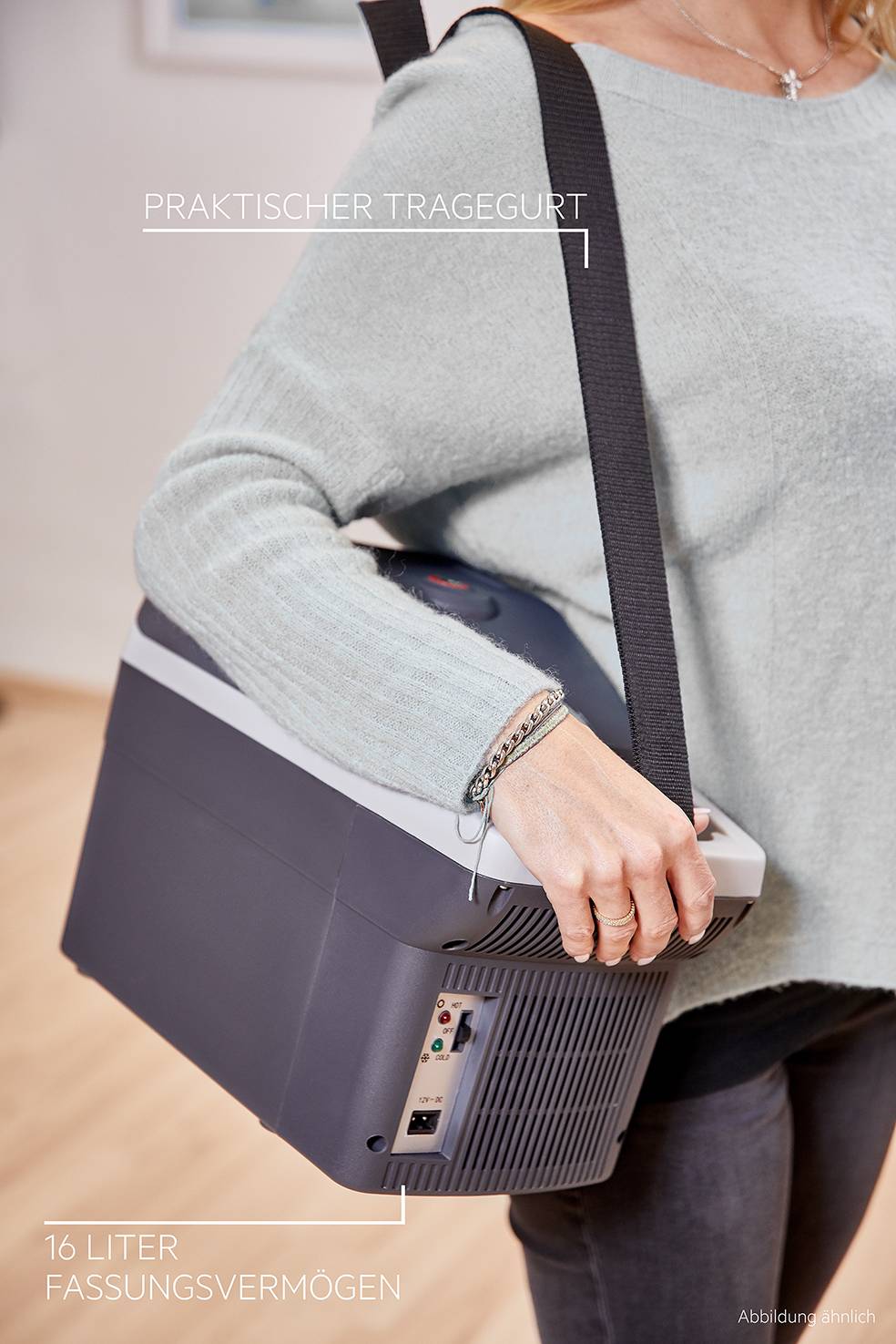 Egy személy egy hordozható hűtőtáskát cipel praktikus vállpánttal. A doboz befogadóképessége 16 liter.