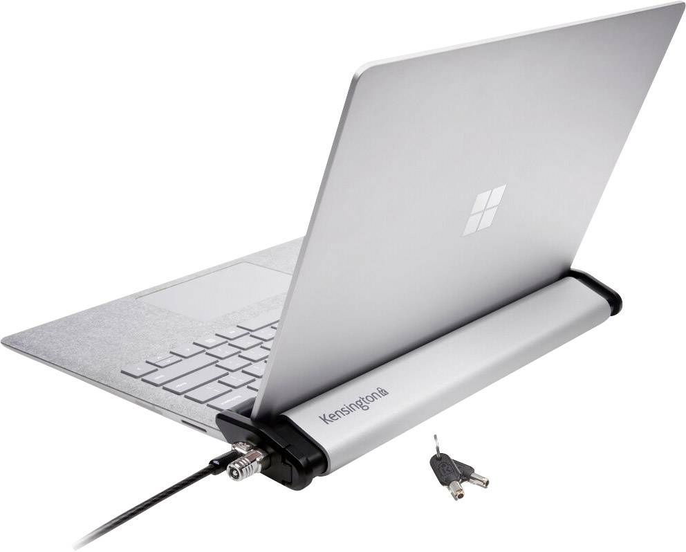 Egy laptop egy Kensington-zárral van biztosítva. Két kulcs fekszik mellette. A zár védelmet nyújt a készülék ellen lopás ellen.
