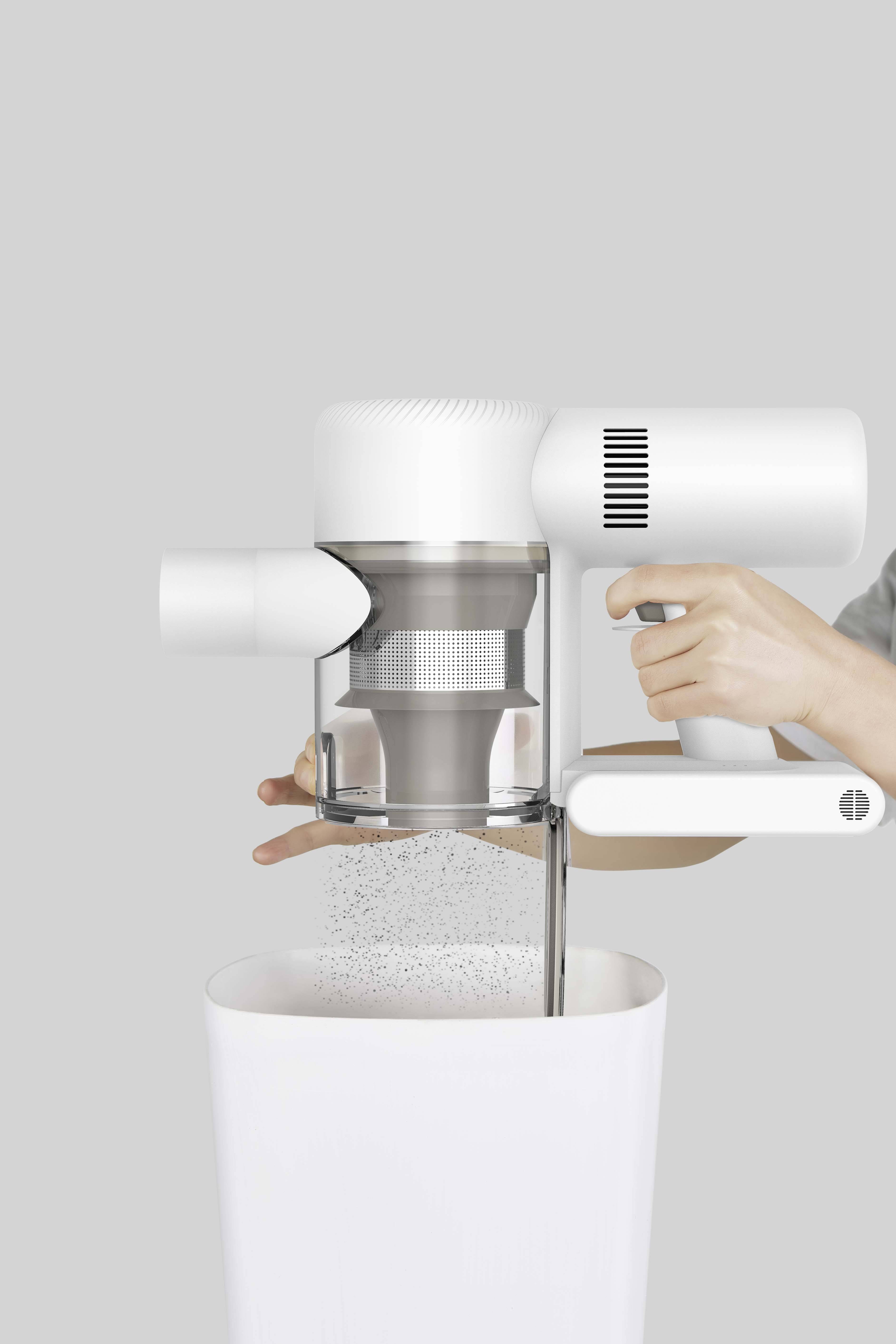 Egy személy kiüríti egy fehér, modern porszívó porgyűjtőjét egy szemétkosárba. A fedél felnyílik.