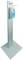 Egy fémből készült adagolóállvány automatikus kézfertőtlenítő készülékkel és felső részén egy papírtörlő tartó sávval.