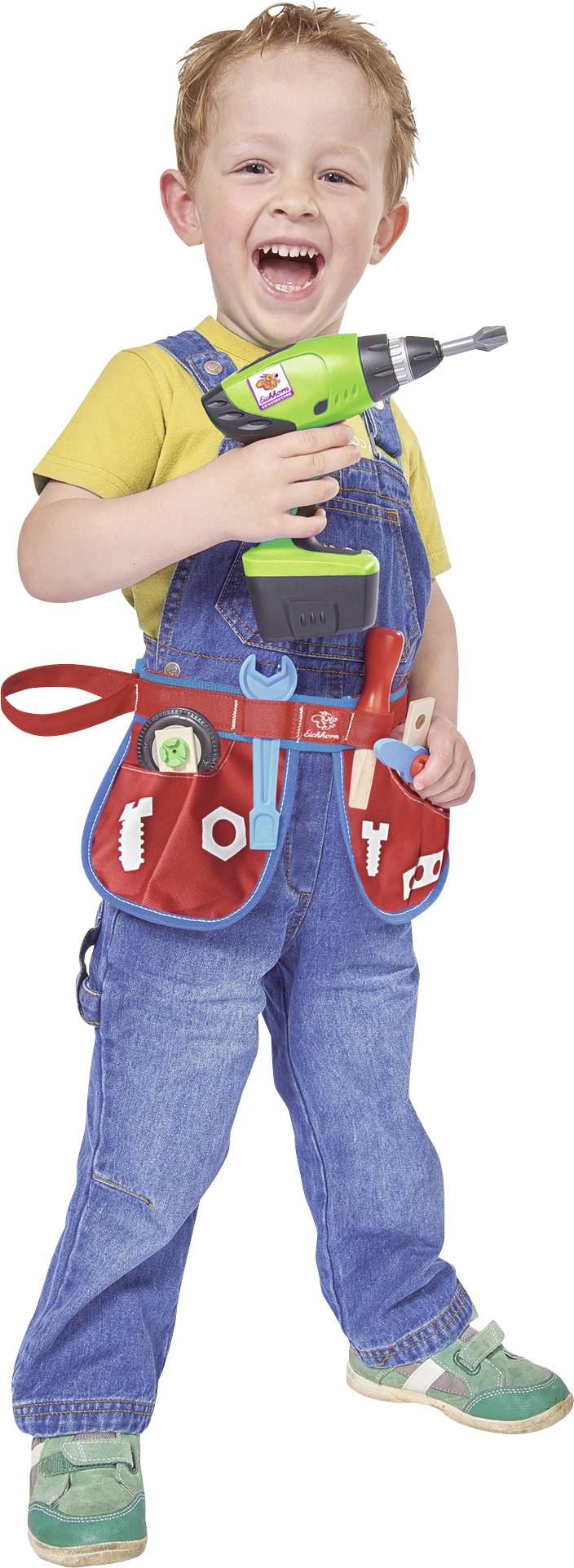 Egy nevető gyerek kék overall-ban és sárga pólóban vidáman tart egy játék fúrógépet a jobb kezében, dereka körül egy szerszámövvel.
