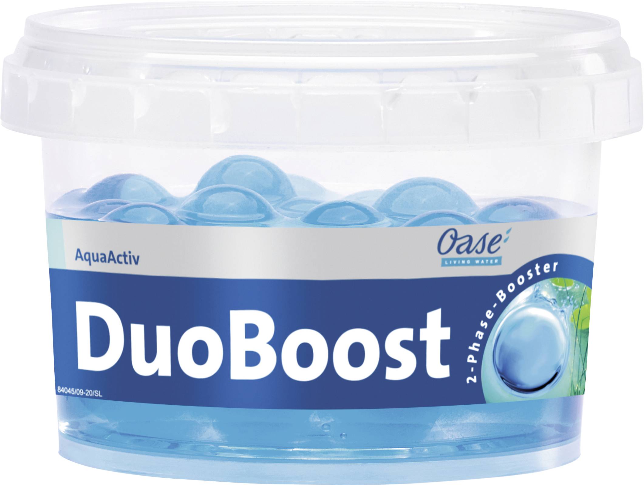 Egy átlátszó műanyag tartály Oase AquaActiv DuoBoost kétfázisú tókezelővel, benne kék kapszulákkal, amelyet a víz minőségének javítására terveztek.