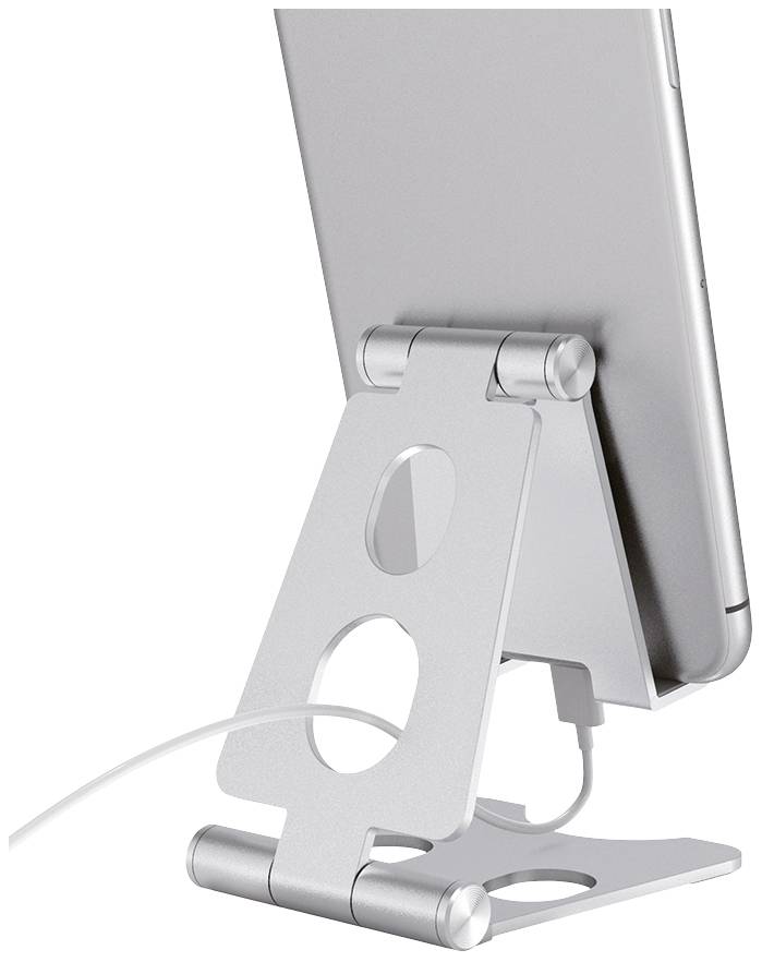 Egy ezüstszínű fémből készült tablet-tartó egy tabletet tart álló helyzetben, miközben töltőkábelen keresztül töltődik.