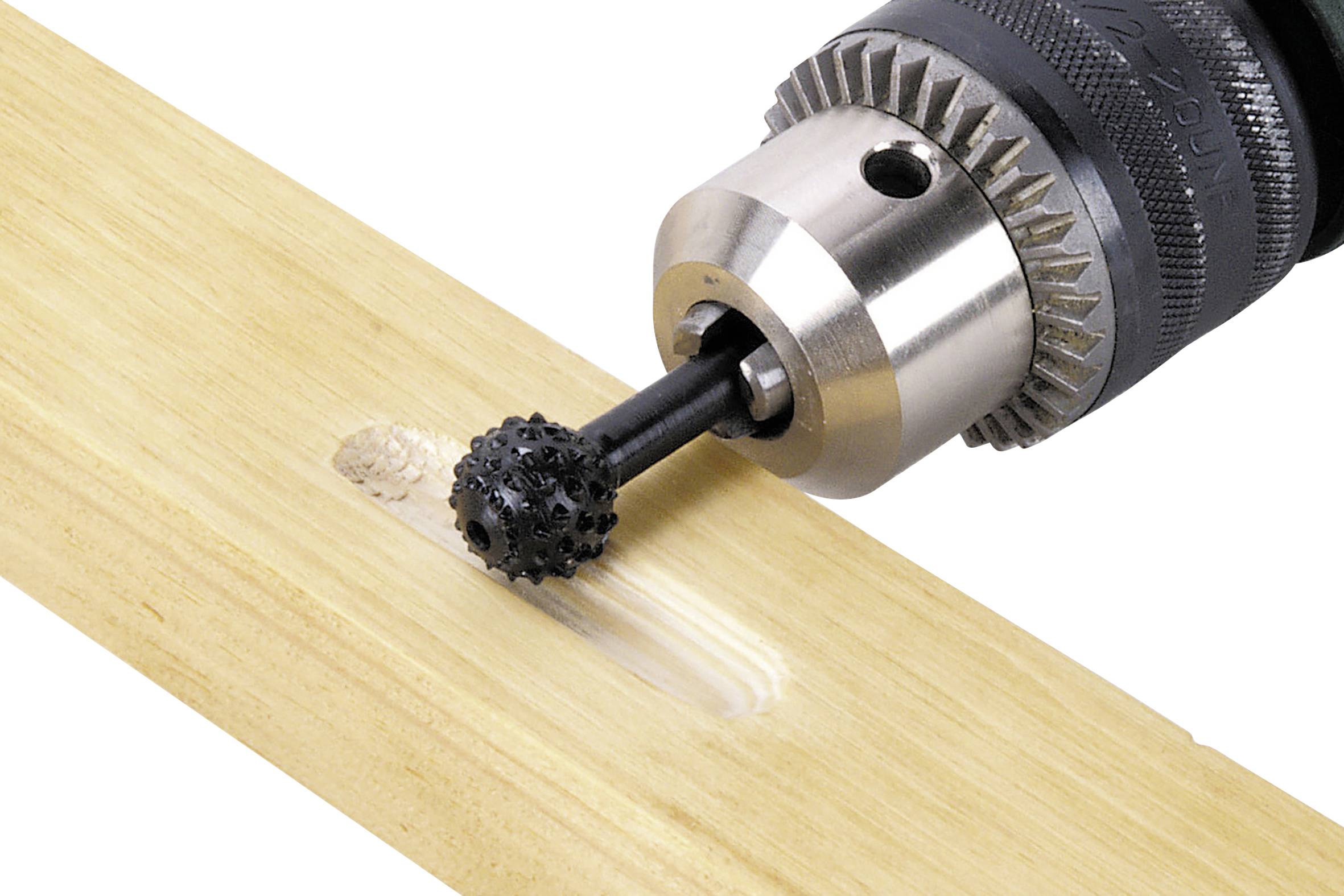 Egy elektromos fúrógép egy darab fát munkál meg, miközben egy fekete csiszolófej lyukat mart bele.