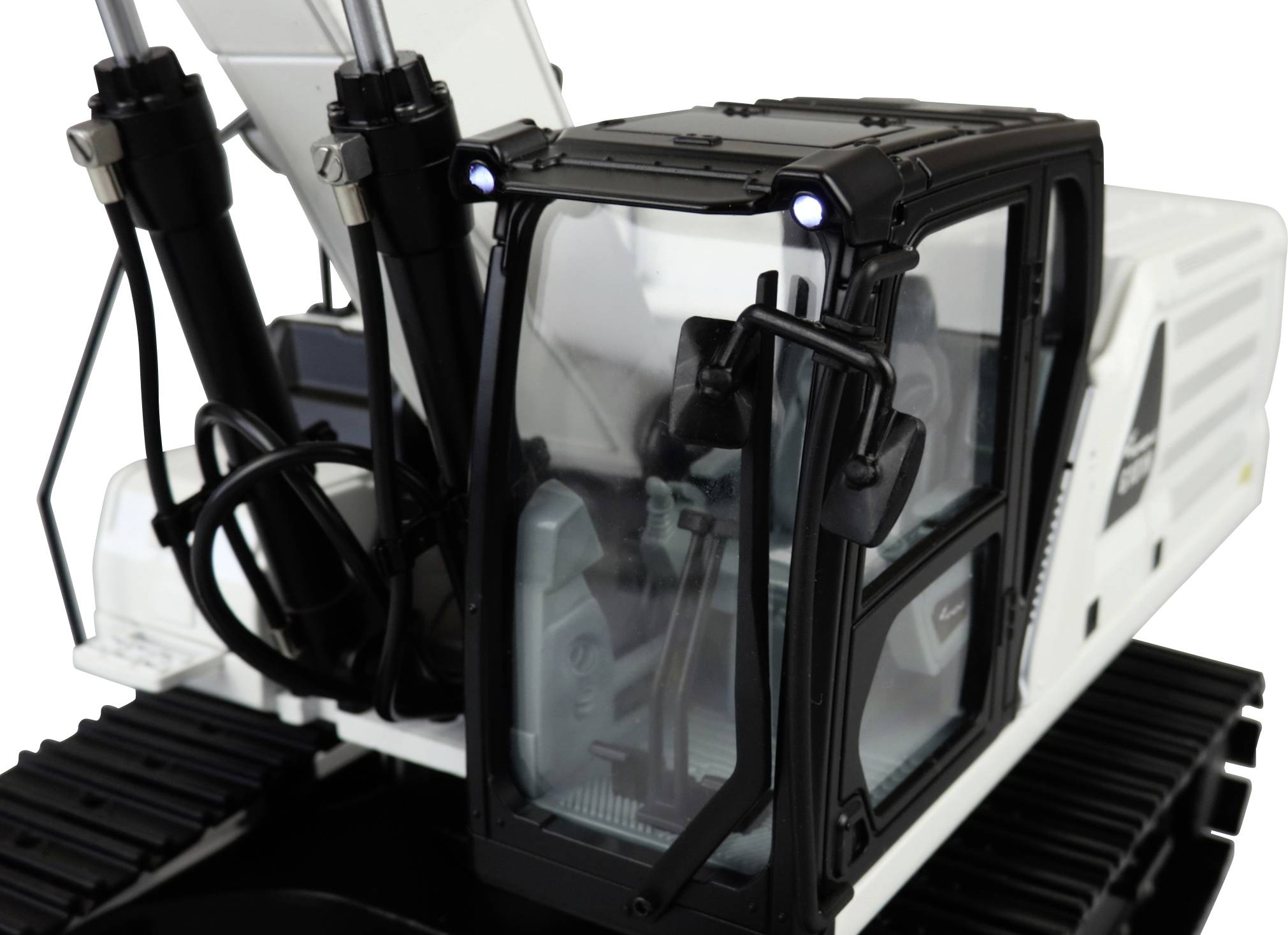 Fehér, precíz kivitelezésű modell egy markoló/kotrógép felépítéséről, fekete vezetőfülkével és látható hidraulikus alkatrészekkel.