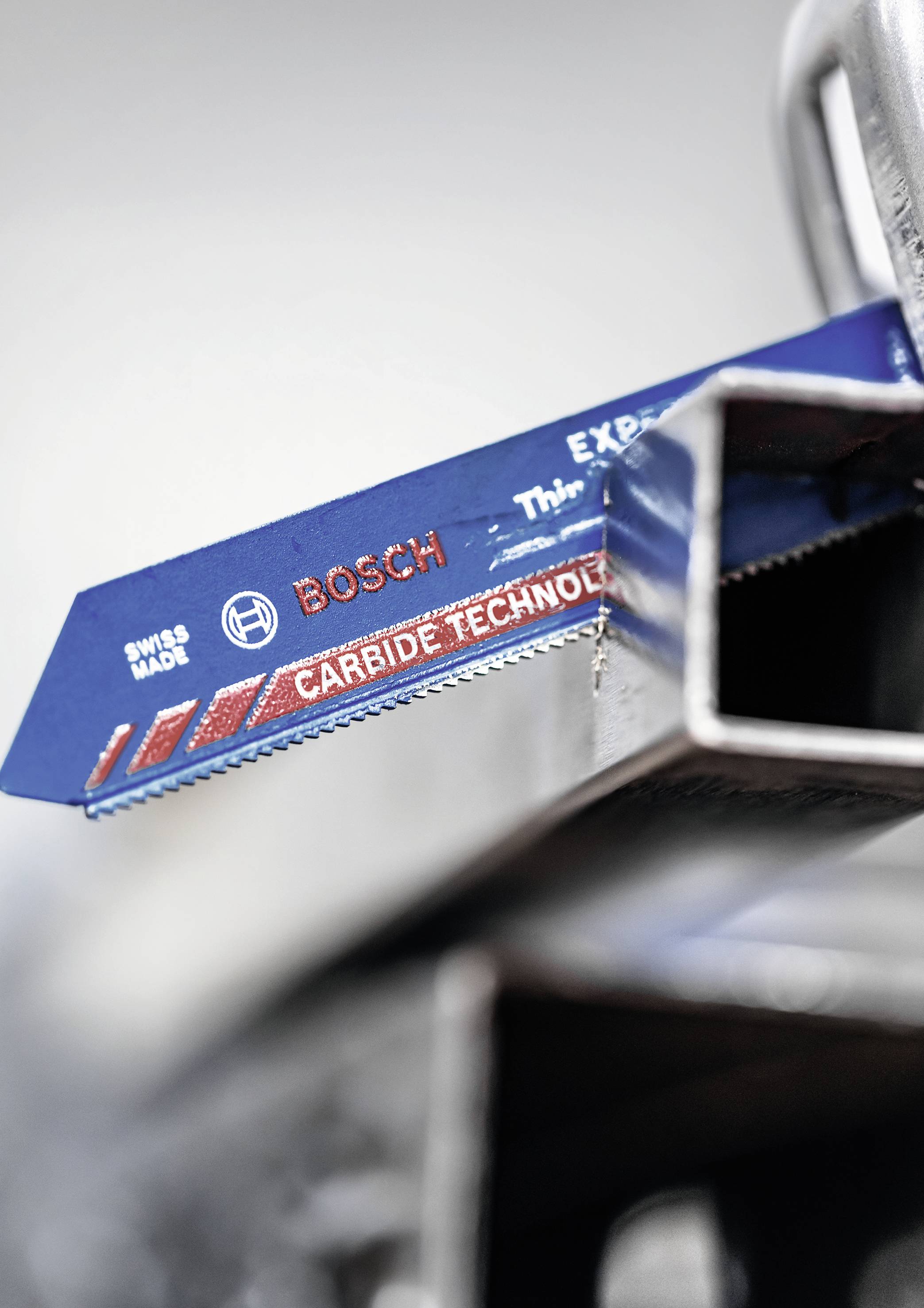 A BOSCH szablyafűrészlap közelről, a 'Carbide Technology' felirattal, fémprofilok mellett elhelyezve.