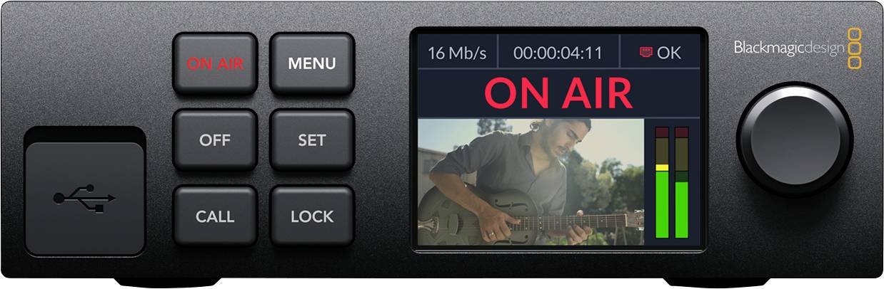 Egy videókészülék gombokkal és képernyővel az 'ON AIR' feliratot mutatja. A képernyőn egy gitáros férfi látható. Irányítja a produkciót és a közvetítést.