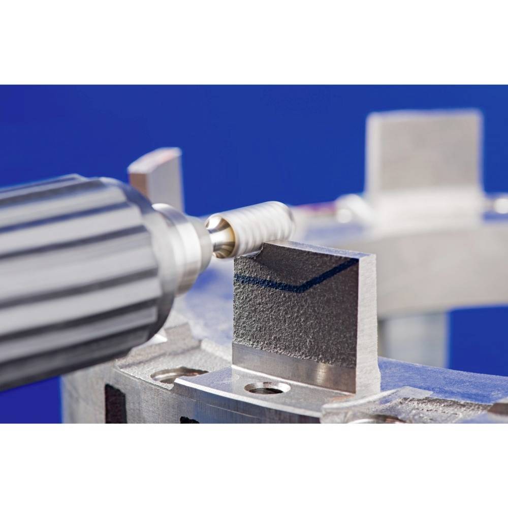 Egy fúró polírozza a fémdarabot egy műhelyben. A hangsúly a fémfelület precíz csiszolásán van.