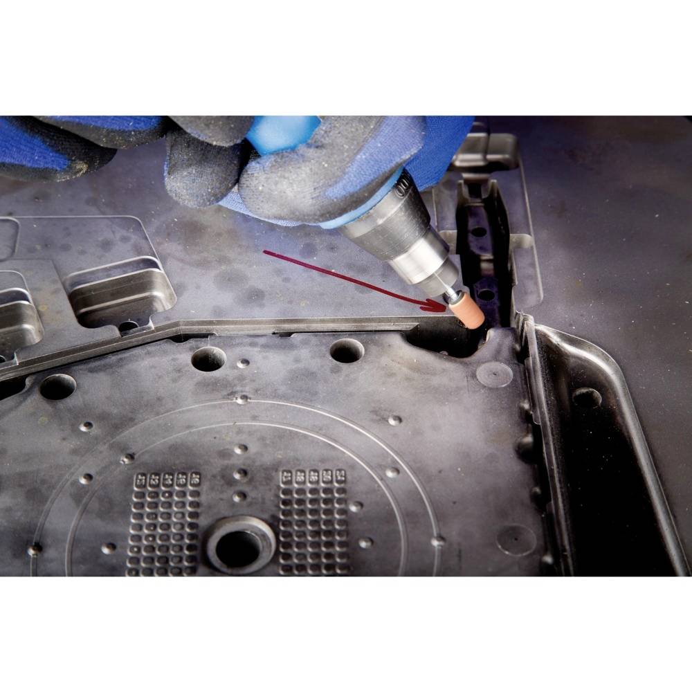 Egy kék védőkesztyűs kéz egy szerszámot használ egy fémdarab hegesztési varratának elkészítéséhez.