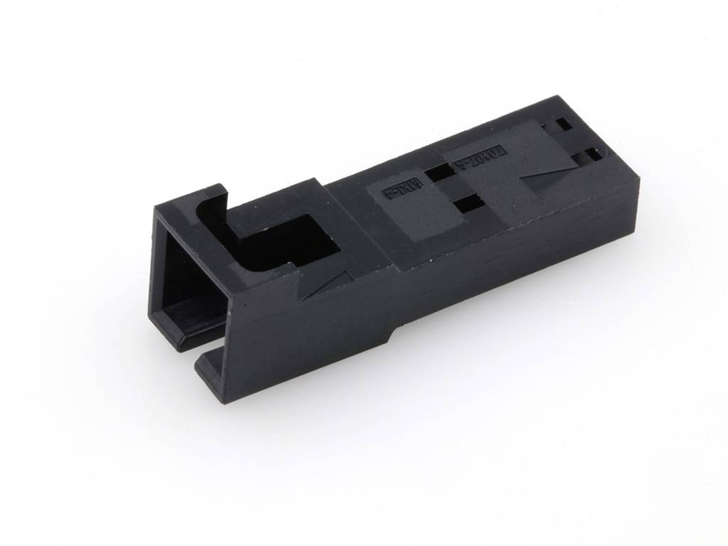 Egy fekete, téglalap alakú műanyag alkatrész kivágásokkal, valószínűleg egy adapter vagy tartóelem, fehér háttér előtt.