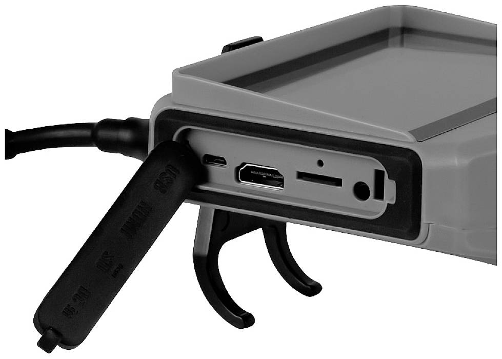 Szürke elektronikus eszköz USB- és HDMI-csatlakozókkal, valamint SD-kártya foglalattal. A kábelek csatlakoztatva vannak.