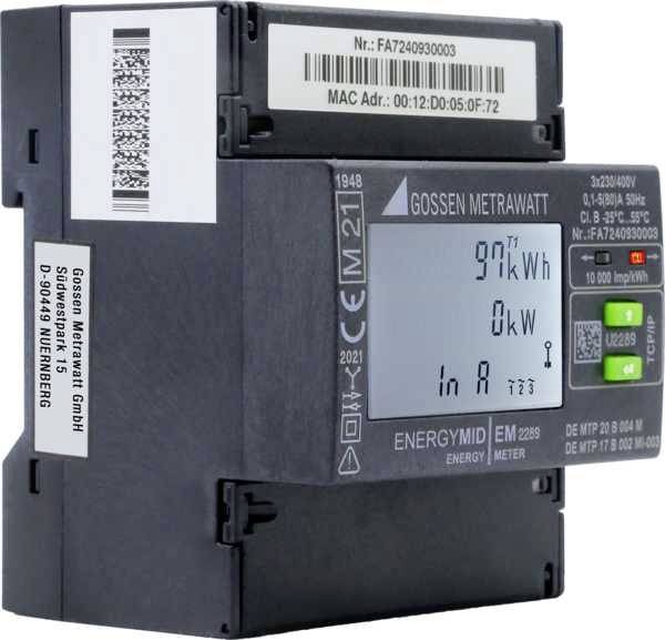 Egy digitális fogyasztásmérő '97 kWh' értéket mutat a kijelzőjén. Jobbra egy zöld gomb helyezkedik el. A gyártó Gossen Metrawatt.