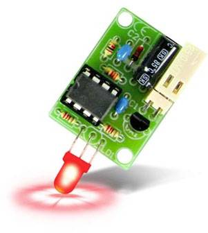 Egy zöld elektronikai modul, amelyen mikrochip, kondenzátorok és egy lefelé világító piros LED-fény található.