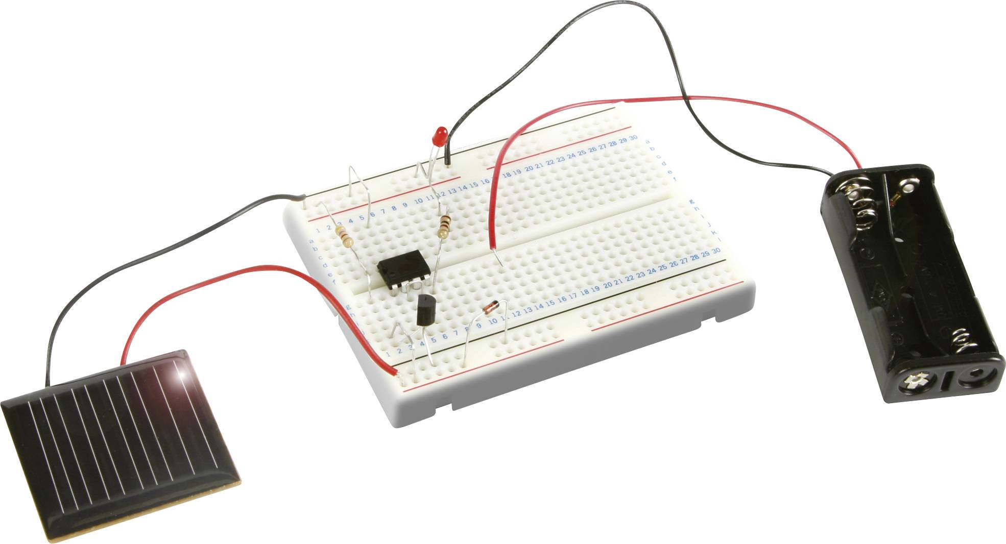Egy breadboard elektronikus komponensekkel, napelemmel és elemtartóval összekötve egy egyszerű áramkört mutat.