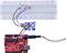 Egy Arduino-val ellátott próbapanel áramkör LED-ekkel. A LED-ek világítanak, ellenállással és érzékelővel bekötve, csatlakoztatva az Arduino-hoz.