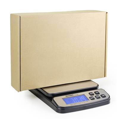 Egy digitális mérleg 7,9 kg-ot mutat, miközben egy nagy, zárt, barna kartondobozt mérlegel.