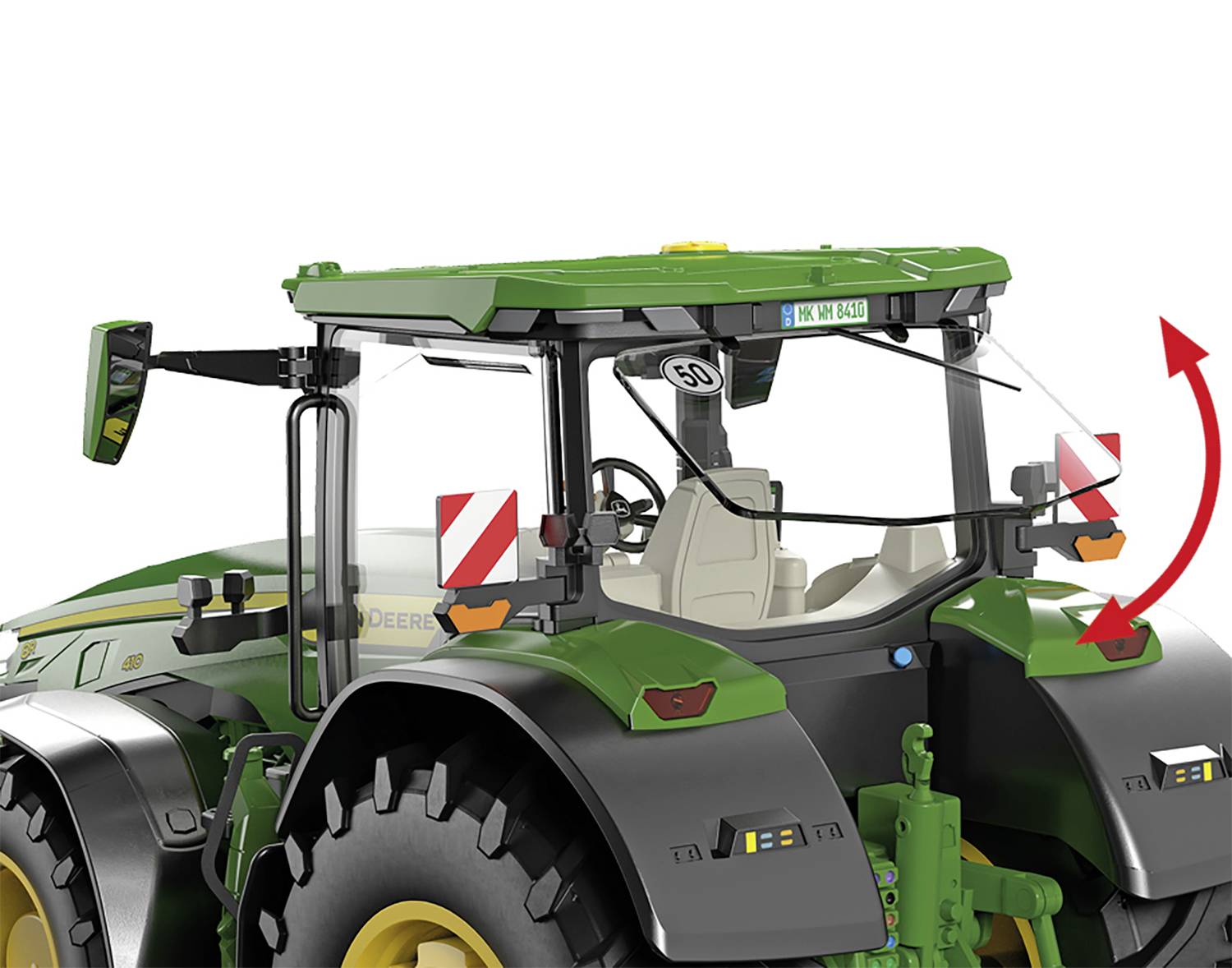 Zöld tetejű traktor nagy kerekekkel, piros nyilak mutatnak a vezető fülke hátoldalán lévő mozgatható alkatrészre.