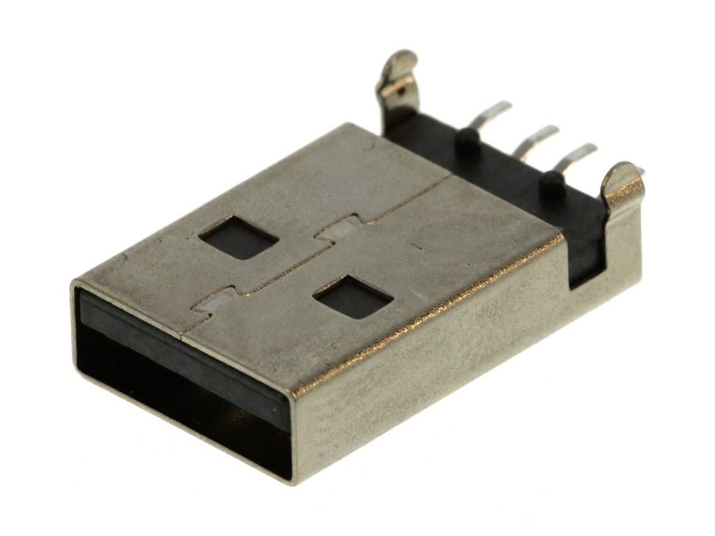 Egy USB-csatlakozó fekszik egy felületen. A fémcsatlakozó jobbra néz, négy érintkezőpont látható.