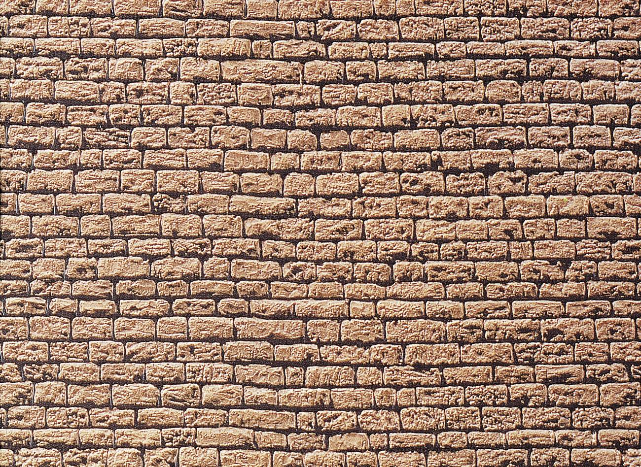 Egy homokszínű téglákból álló fal, amelyeket egyenletes sorokban egymásra raktak.