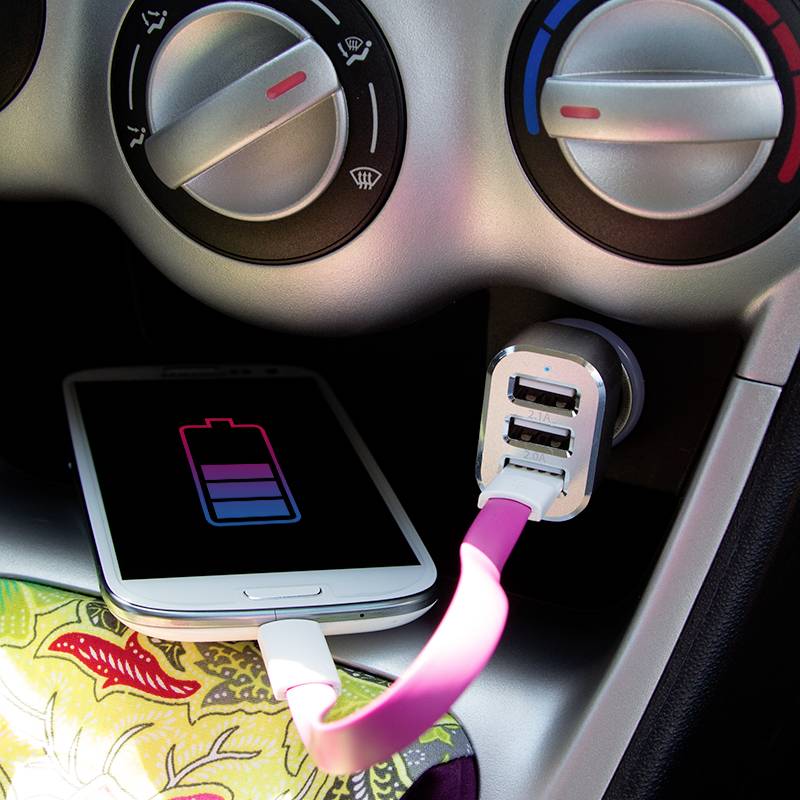 Okostelefon töltődik az autóban. A kijelző egy töltési szimbólumot mutat. Két USB-csatlakozó látható az adapterben.