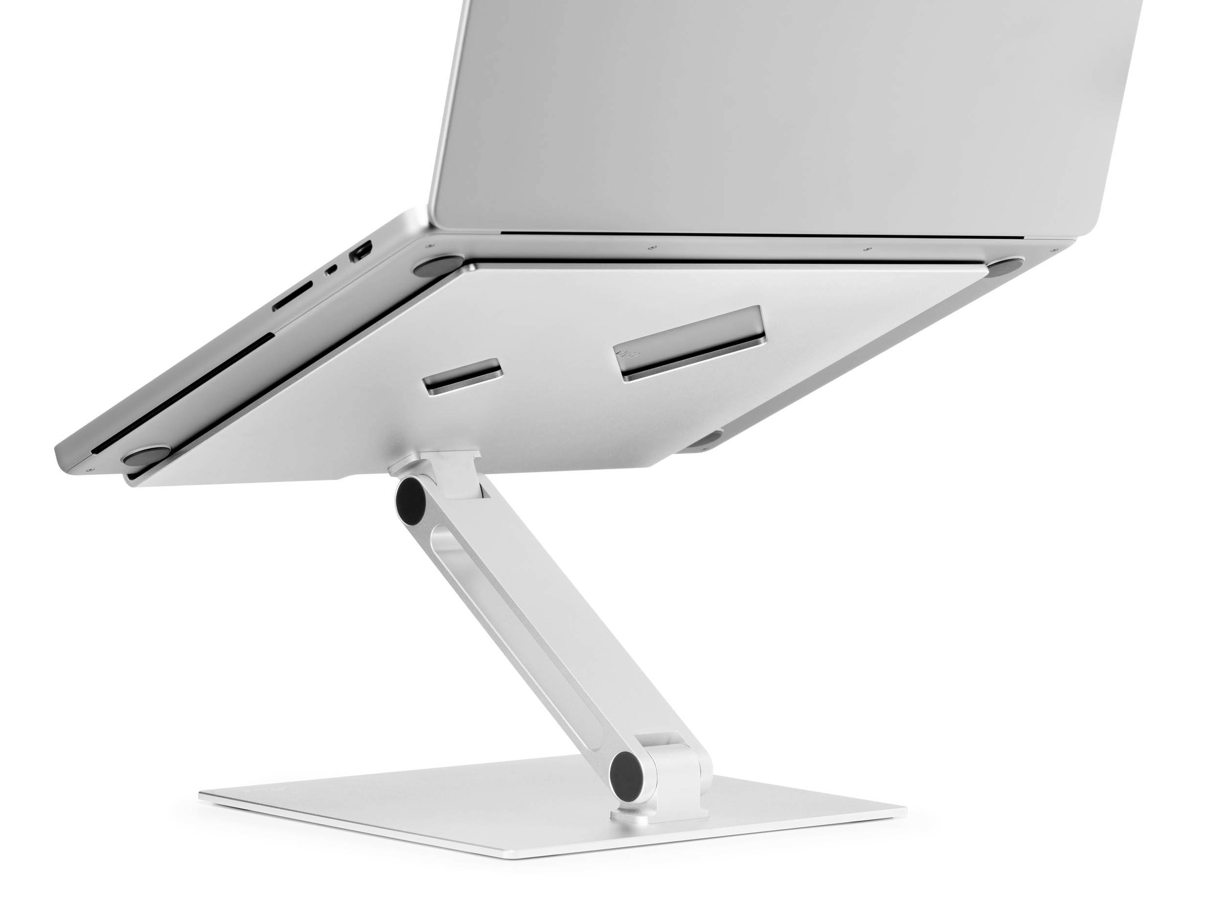 Egy laptop egy állítható fehér tartón, amely lehetővé teszi a szellőzést és megkönnyíti az ergonomikus munkavégzést.
